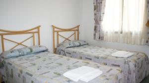 Łóżko lub łóżka w pokoju w obiekcie Apartamentos Hipocampos Unitursa