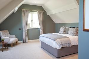 a bedroom with a bed and a chair at Beckford Inn in Beckford