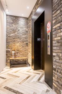 an elevator in a lobby with a brick wall at Easylazy Inn in Taichung