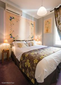 1 dormitorio con 1 cama grande y cabecero de flores en Hotel Villa La Tour, en Niza 121 fotos más