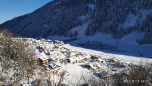 een klein dorp bedekt met sneeuw op een berg bij Appartamenti Presanella in Vermiglio