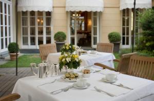 a table with white table cloths and flowers on it at Grand Hotel Sitea in Turin