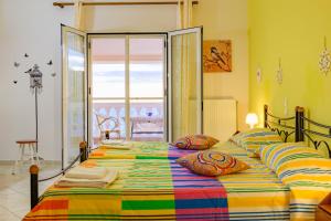 een slaapkamer met een groot bed en een kleurrijke deken bij Tolis aparts in Pelekas