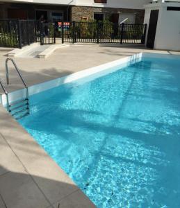 キャヴァレール・シュル・メールにあるModerne T2 avec garage ,très calme avec jardin privé et piscine, à 400m du centre ville et des plages, WIFI remise supplémentaire de 10 pourcent pour une location à la semaineの建物内の青い水のプール