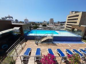 a swimming pool with lounge chairs on a building at Hotel Catedral Plaza in Santa Marta