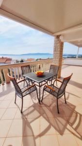 a table and chairs on a balcony with a view at Apartments Crljen in Brodarica