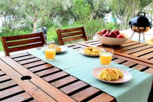 ein Tisch mit Tellern voller Essen und einer Schale Obst in der Unterkunft Vila Nova de Santa Susana - Resort in Alcácer do Sal