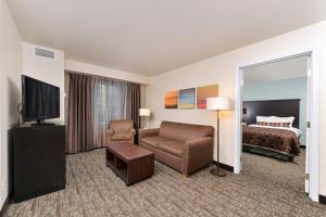 Staybridge Suites Sioux Falls at Empire Mall, an IHG Hotel في شلالات سيوكس: غرفة في الفندق مع أريكة وسرير