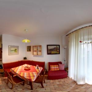 ein Wohnzimmer mit einem roten Sofa und einem Tisch in der Unterkunft Penzion U Lesa in Budweis