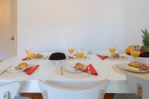 a table with plates of food and glasses of orange juice at Spacious Comfortable Apartment - Balcony in Porto