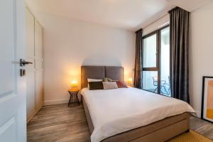 a bedroom with a large bed and a large window at Onix 75 in Mamaia Sat/Năvodari +22 photos