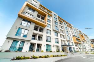 a tall white building with windows on a street at Onix 75 in Mamaia Sat/Năvodari