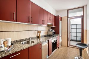 馬西尼古蒂的住宿－Villa Beatrice，一间带红色橱柜和水槽的厨房