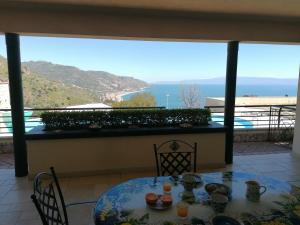 een tafel en stoelen met uitzicht op de oceaan bij Taormina Lux & Elite Apartments - Taormina Holidays in Taormina
