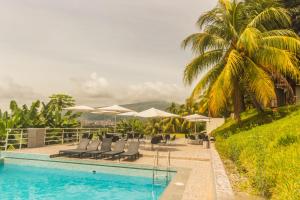 a pool at a resort with chairs and umbrellas at Urqu Hotel & Boutique in Jaén