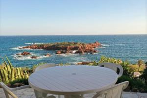 uma mesa e cadeiras brancas com vista para o oceano em Waterfront House With Sea View em Saint-Raphaël