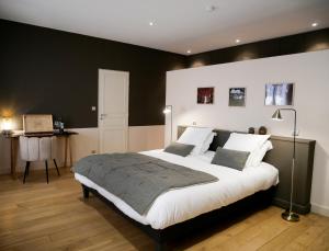 ein Schlafzimmer mit einem großen Bett und einer schwarzen Wand in der Unterkunft Clos des Jacobins (Grand Cru Classé) in Saint-Émilion