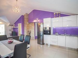 a kitchen with purple walls and a table and chairs at Apartment Sanja in Povlja