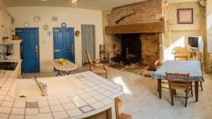 eine Küche und ein Wohnzimmer mit einem Kamin in der Unterkunft Maison Pierre Loti, gîte historique et spacieux en vallée de la Dordogne in Bretenoux