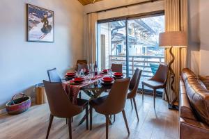 uma sala de jantar com uma mesa e cadeiras e uma janela em La Cordee 124 Apartment - Chamonix All Year em Chamonix-Mont-Blanc