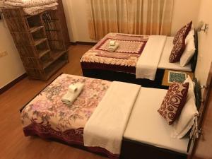 a room with three beds in a room at Hotel Cherry Garden in Pokhara