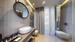 a bathroom with a sink and a mirror at GALLERIA The Smart Boutique APARTHOTEL By OSPITAMI in Milan