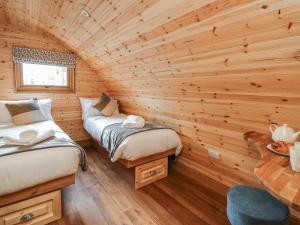 a room with two beds in a log cabin at Bluebell in Rhayader