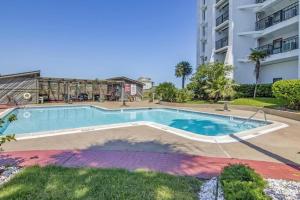 una piscina frente a un edificio en Seawall Apartments, en Galveston