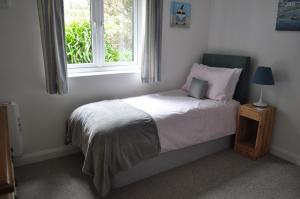 Dormitorio pequeño con cama y ventana en Morley's, en Stithians