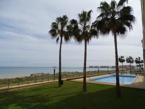 - une vue sur la piscine bordée de palmiers et l'océan dans l'établissement Dos Mares Admer 01, à La Manga del Mar Meno