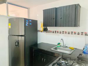a kitchen with a refrigerator and a sink at Santa Marta Apartamentos Salazar - Caribe in Santa Marta