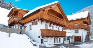 a house with snow on the roof of it at Pinterhof in San Vigilio Di Marebbe