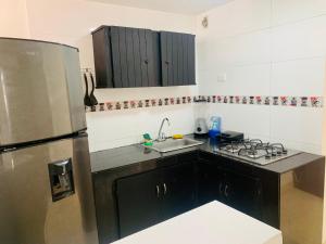 a kitchen with a stainless steel refrigerator and a sink at Santa Marta Apartamentos Salazar - Caribe in Santa Marta