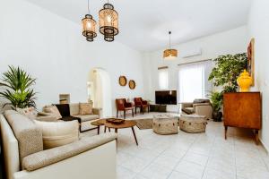 Chania Paradise Retreat - Falasarna Villa Nostalgia في Plátanos: غرفة معيشة مع أريكة وطاولة