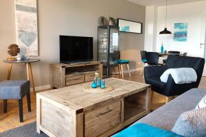 a living room with a tv and a couch and a table at fewo1846 - FoerdeNest - familienfreundliche Wohnung mit 2 Balkonen und Meerblick in Harrislee