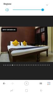 a picture of a bed with yellow pillows on it at shri bake bihari guest house in Gwalior