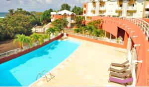 vista sulla piscina di un edificio di RÉSIDENCE DE LA BAIE Sunshine TARTANE a La Trinité