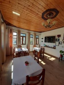 een eetkamer met tafels en stoelen en een plafond bij B&BSheshalliu in Berat