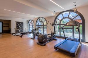 - une salle de sport avec tapis de course et vélos elliptiques dans une pièce dotée de fenêtres dans l'établissement La Cordee 124 Apartment - Chamonix All Year, à Chamonix-Mont-Blanc