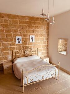 una camera con letto e muro di mattoni di Corte San Giorgio a Matino