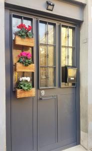 szare drzwi z kwiatami i oknami w obiekcie Trastevere Sweet Home w Rzymie