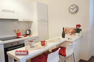 kuchnia ze stołem z krzesłami i zegarem na ścianie w obiekcie Trastevere Sweet Home w Rzymie +11 zdjęć