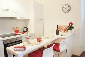 una cucina con tavolo, sedie e orologio di Trastevere Sweet Home a Roma