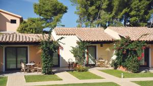 a house with a patio and a table and chairs at SECRET VILLAGE Budoni in Budoni