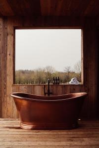 a wooden bath tub in a room with a window at Glasson LakeHouse in Athlone