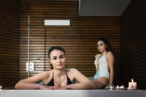 Due donne sedute nella vasca da bagno di fronte a uno specchio di Hotel Mirasole International a Gaeta