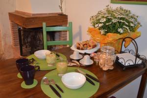 une table avec une assiette de nourriture et de fleurs dans l'établissement B&B Foresteria Della Certosa, à Collepardo