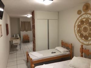 a room with two beds and a table in it at Pousada Serra Negra in Bezerros