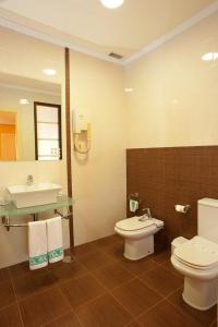 La salle de bains est pourvue de toilettes et d'un lavabo. dans l'établissement Hotel Holiday, à Nigrán