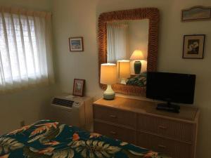 a bedroom with a bed with a television and a mirror at Wailua Bay View Resort in Kapaa